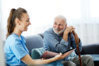 Image of an older man talking happily to a care worker